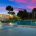 Red Roof Inn Vero Beach - I-95 pool at dusk with palm trees and colorful sunset sky