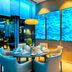 Leonardo Hotel Munich City South dining area with round table and blue-lit wall panels in Munich