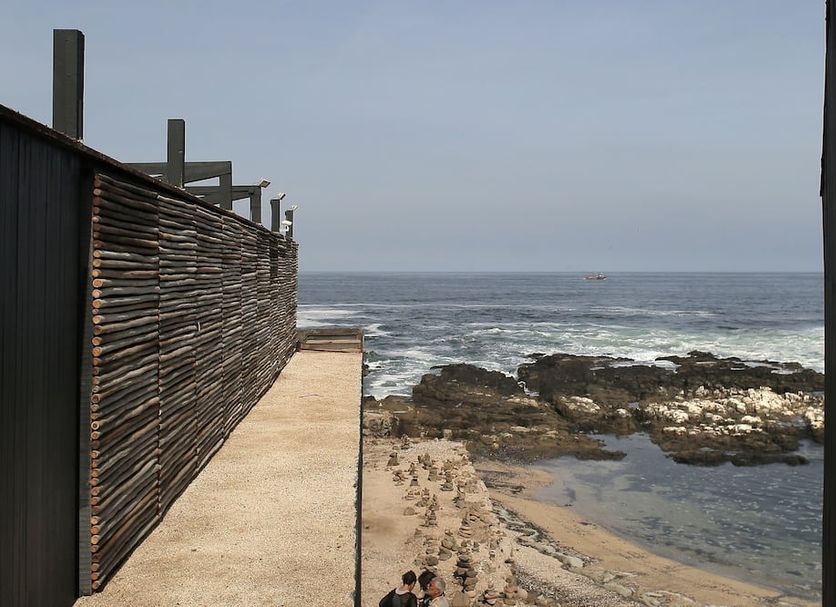 Hotel Apacheta in Arica with oceanfront walkway and rocky beach view