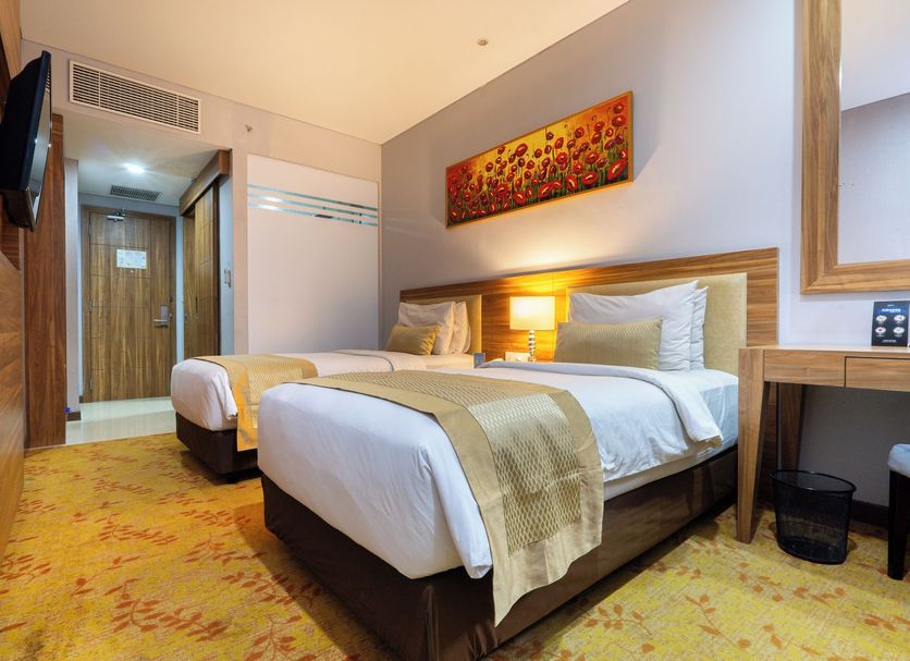 Grand Serela Yogyakarta twin guest room with wood headboard, desk and wall-mounted TV