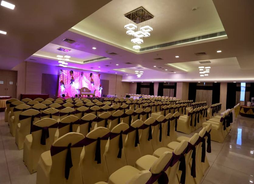 NK Grand Park Hotel Chennai banquet hall with rows of chair-covered seating and stage lighting