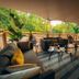 Glamping Village Orlando in Chianti, Cavriglia: covered outdoor lounge deck with sofas and forest views