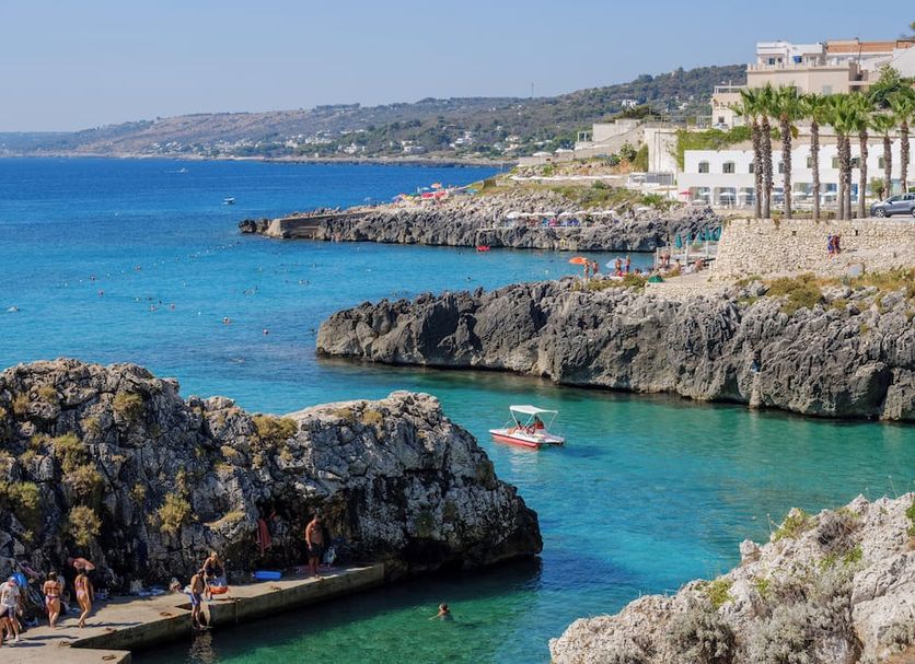 Hotel La Roccia in Castro di Lecce overlooking a rocky cove with turquoise sea and a small boat
