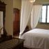 Agriturismo La Capitata in Pian di Scò bedroom with canopy bed, wooden armoire and dresser