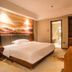 Wuyue Yuexin Hotel (Jinggangshan) room with bed, wall art, TV, and bathroom doorway in Ji'an
