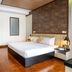 Lcs Hotel & Apartment in Phnom Penh guest room with king bed, wood floors, wall-mounted TV, and desk