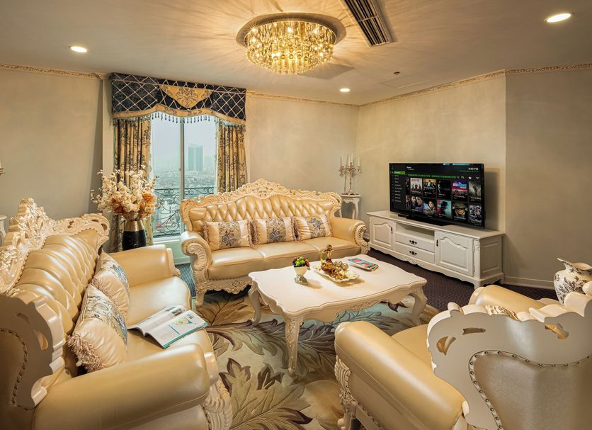 Super Candle Hotel Hanoi suite with ornate seating, chandelier, TV, and city view
