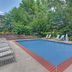 Travelodge by Wyndham Williamsburg Colonial Area pool with lounge chairs and trees in Williamsburg