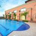 Mestil Hotel & Residences in Kampala with a palm-lined outdoor swimming pool beside a peach-colored building