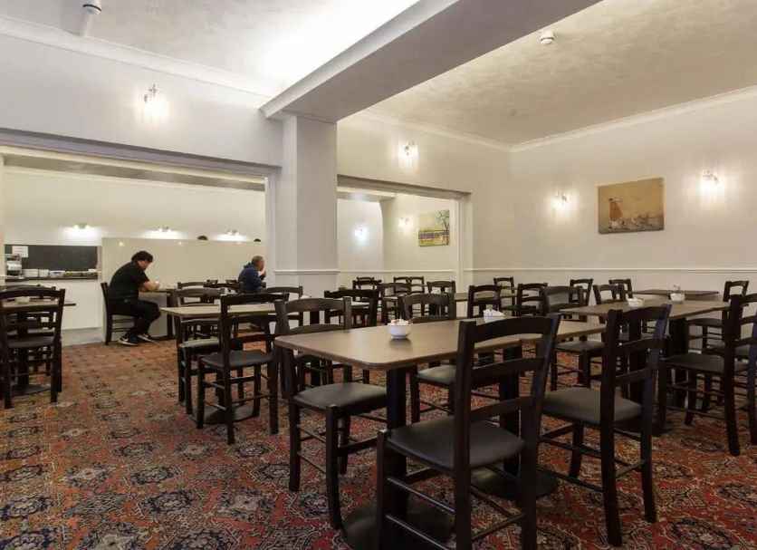 The Glendeveor in Newquay dining room with wooden tables and chairs and patterned carpet