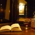The Leather Bottle in Gravesend: warmly lit bar table with open book, glass decanter, wine and candle