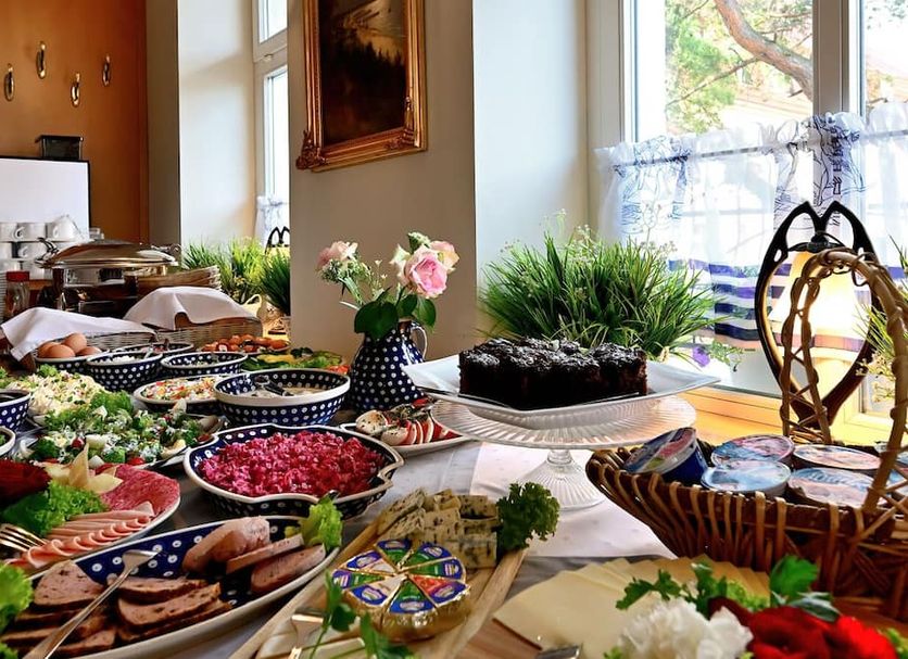 Villa Nautilus in Międzyzdroje breakfast buffet with smoked fish, fruit, pastries and flowers by a bright window