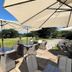 The Upper House in Stoke-on-Trent patio seating with umbrellas overlooking a grassy garden
