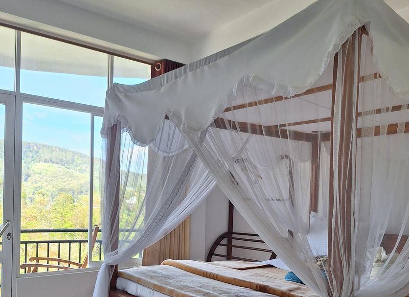 Lilly Guest Inn in Haputale, four-poster bed with mosquito net and balcony mountain view