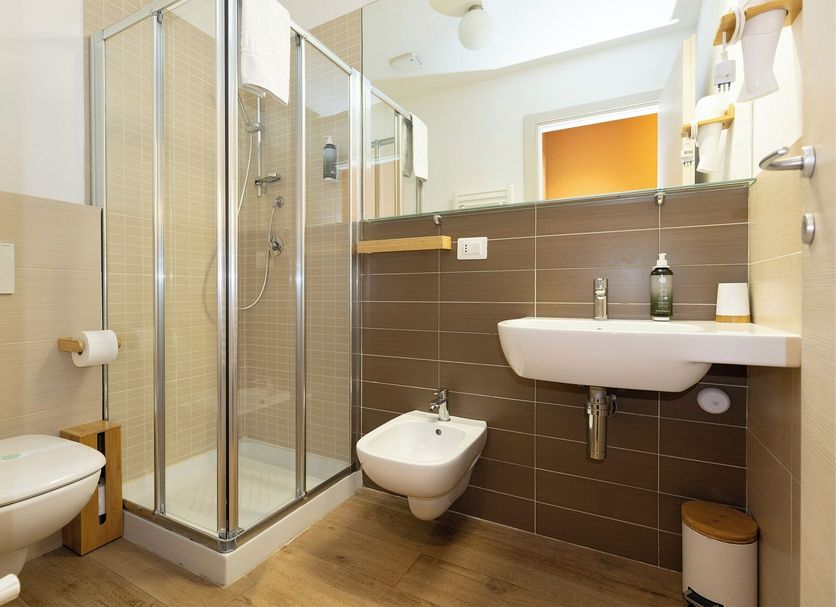 La Loggia de' Banchi bathroom with glass shower, wall-mounted sink, and bidet in La Spezia