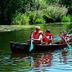Guests canoe on a calm lake at Hotel Amberger Hof in Bad Kotzting, surrounded by greenery.