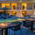 Divani Escape, Vouliagméni: illuminated outdoor pool terrace with dining tables and lounge chairs