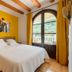 Agroturismo Ca Sa Vilda Marge guest room in Sant Joan de Labritja with arched balcony door and yellow walls