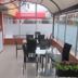 Hotel Casa Lamay in Bogotá: covered terrace dining area with glass walls and black tables and chairs