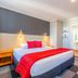 The Grosvenor, Timaru guest room with king bed, red throw, bedside lamps and en suite access
