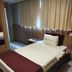 Esplanada Brasilia Hotel guest room with single bed, curtains and wood-paneled wall in Brasilia
