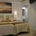 Hotel Doña Lina Seville twin room with framed waterfront wall art and bedside lamps