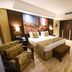 Mestil Hotel & Residences in Kampala, guest room with king bed, armchair, bench and cityscape wall art