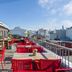 Loft - Hi Eco Hostel rooftop terrace in Reykjavik with red tables, chairs and city views
