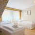 Allegro Hotel Ljubljana room with two single beds, floral wallpaper, and a small vanity desk