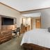 Norfolk Lodge & Suites, an Ascend Collection Hotel room with king bed, desk, and kitchenette in Norfolk