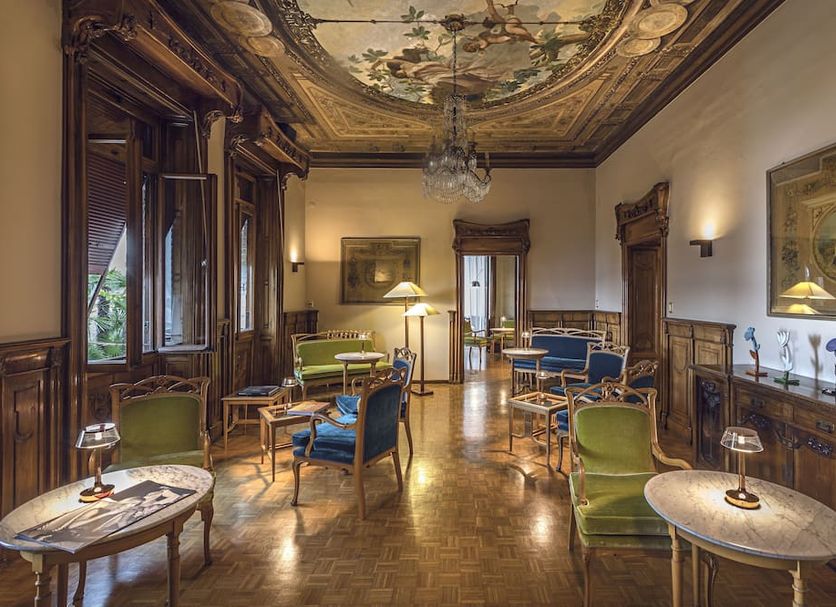 Hotel Laurin in Salò elegant lounge with frescoed ceiling, antique furnishings, and large windows