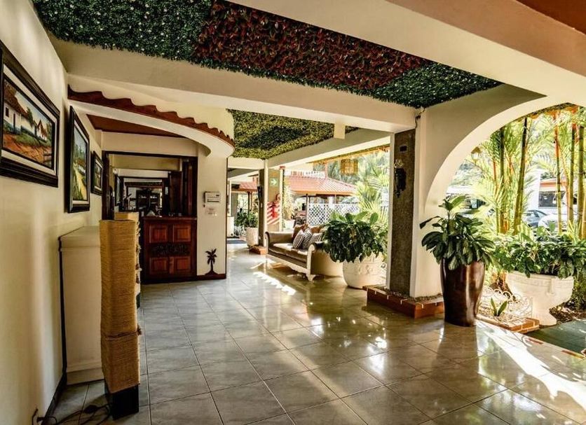 Hotel Villabosque Eco Boutique in Manuel Antonio: covered open-air lobby corridor with seating and potted plants