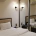 Seven Days Hotel Irbid guest room with bed, wall sconces and mirrored wardrobe