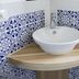 B&B Il Cavaliere in Santa Domenica: white vessel sink on wooden corner shelf with blue patterned tiles