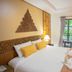 100 Islands Resort & Spa in Surat Thani guest room with king bed, carved headboard, and garden view patio