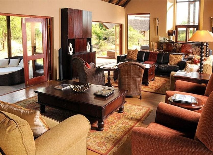 Pilanesberg Private Lodge in Pilanesberg lounge with wicker seating, coffee table and large windows