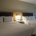 Hampton Inn Boise-Airport guest room with two queen beds, bedside lamp, chair, and window in Boise