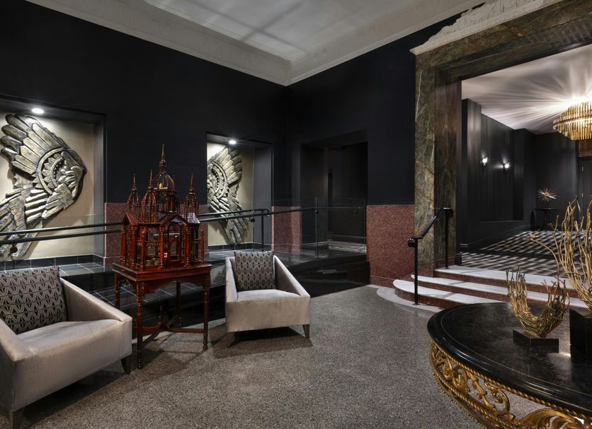 The Warrior Hotel, Autograph Collection in Sioux City: stylish lobby seating, ornate wall art, and a decorative table