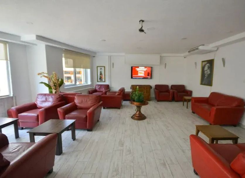Kosk Sivas lobby lounge in Sivas with red sofas, coffee tables, and wall-mounted TV