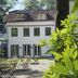 Hardtwald, Bad Homburg hotel exterior with garden seating and a white facade