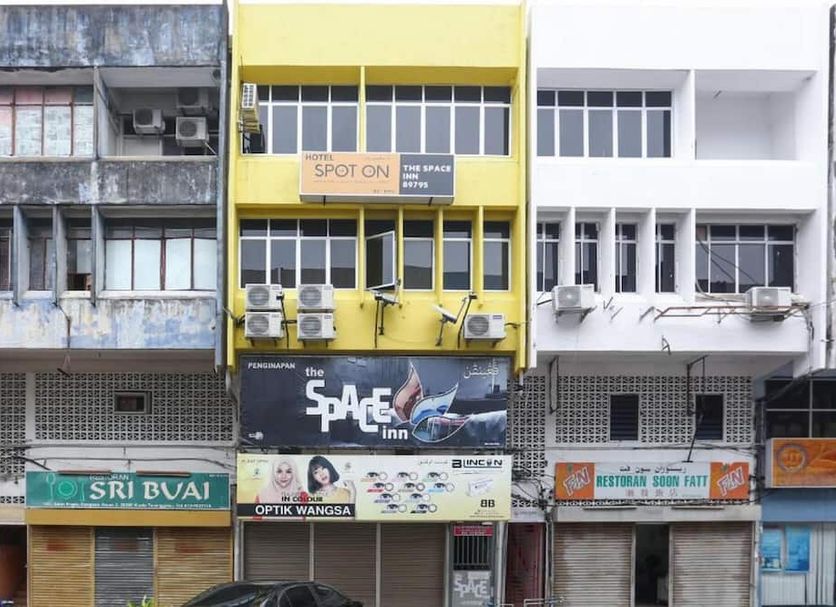 Hotel O The Space Inn in Kuala Terengganu, yellow facade with signage on a row of shopfronts