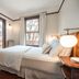 Naramata Inn guest room with king bed, window view, and bedside lamps in Naramata