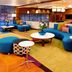 Fairfield Inn & Suites Parsippany lobby lounge with blue curved seating, tables and warm lighting