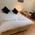 Westside Studio Apartments in Armidale, studio bedroom with striped bed, bedside lamps and desk