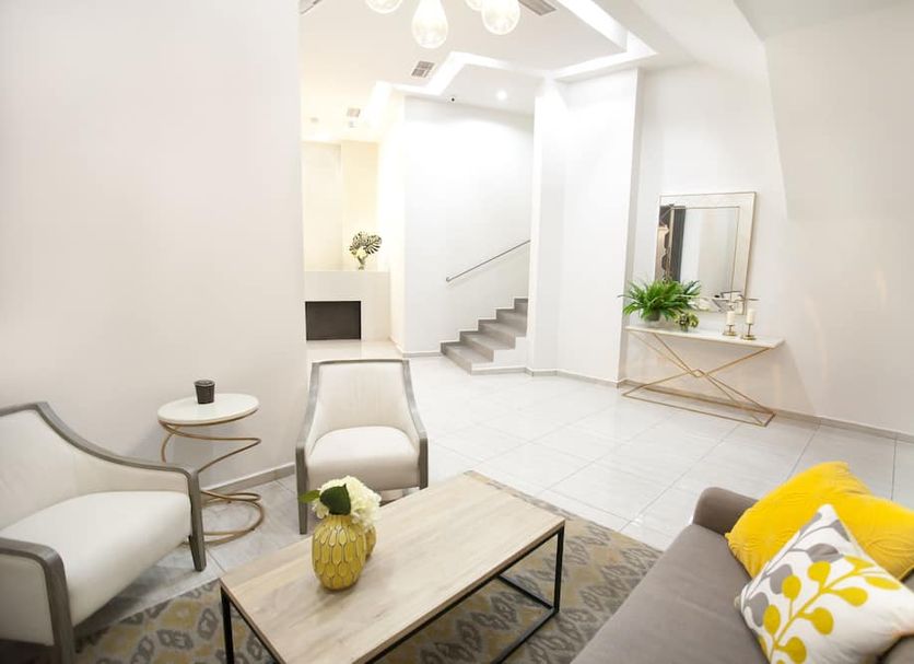 Hotel Los Andes lobby lounge in San Pedro Sula with seating area, staircase, and console table