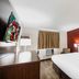 Red Roof Inn Bristol guest room with king bed, wall-mounted TV, desk and window air conditioner