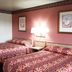 OYO Hotel Kings At Clovis guest room with two double beds and patterned red bedding in Clovis