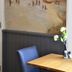 Fletcher Badhotel Egmond aan Zee interior with seaside mural, wooden table and blue chair