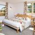 Hotel Mas Djoliba in Antibes room with double bed, floral bedding, balcony view and flower vase