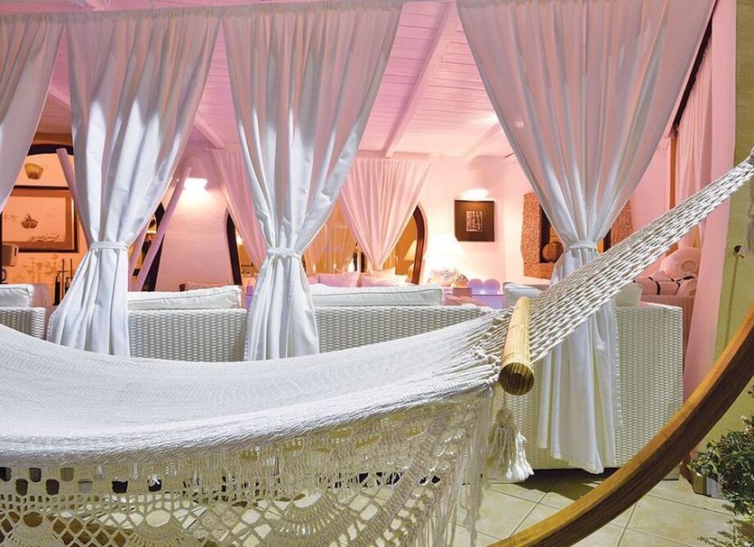 Baia del Porto in Budoni with a white hammock and curtained lounge seating